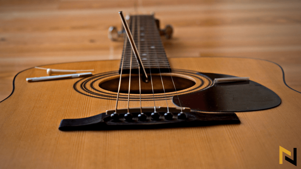 displays acoustic guitar, hex key and truss rod adjusting