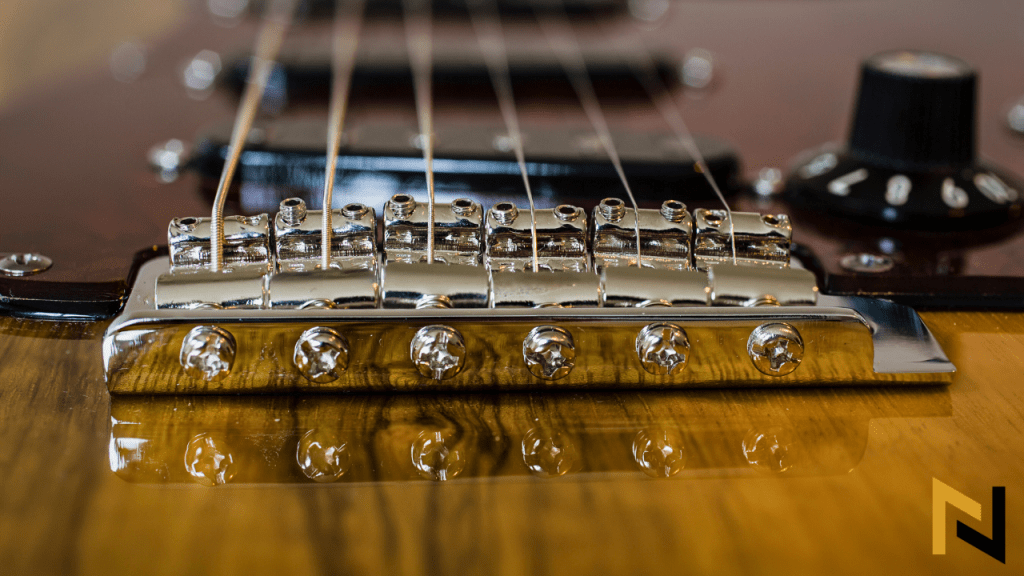 Displays bridge of an electric guitar and intonation screws