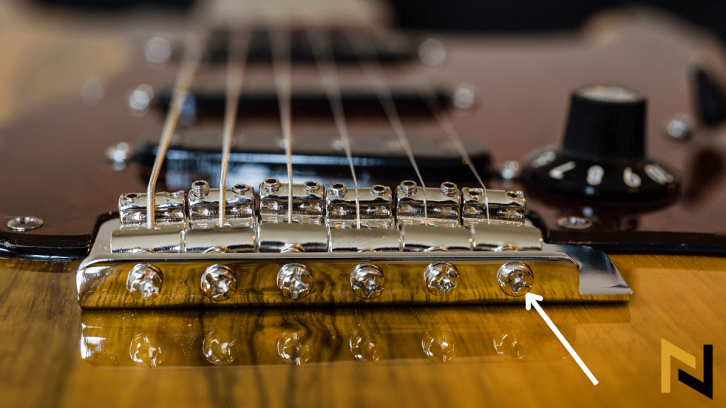 displays how to adjust intonation of an electric guitar with Stratocaster Bridge