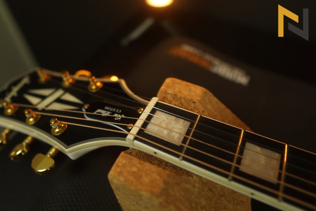 Displays Epiphone Les Paul Custom electric guitars nut and headstock